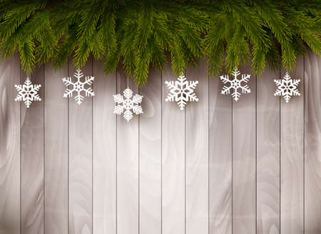 Background with Christmas tree branches and snowflakes in front of a wooden wall. Vector.のイラスト素材