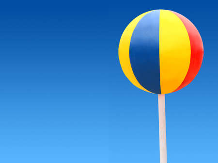 Big color beach ball on a blue sky. Looks like a sweet candy. 