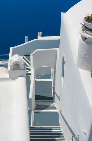 White narrow street with long staircase and traditional architecture on island of Santorini in Fira, Greece.の写真素材