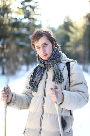 Portrait of beautiful young man cross-country skiing on a sunny winter day through the forestの写真素材