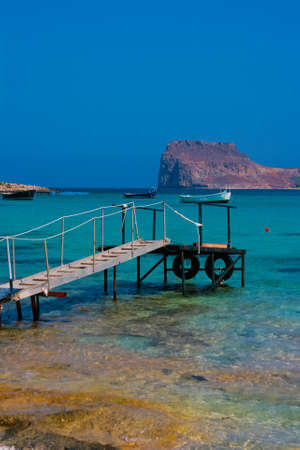 Pier with boats in Balos Lagoon and Gramvousa island on Crete, Greeceの写真素材