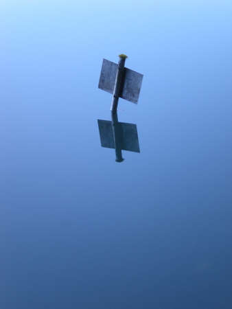 blue sign poking out of a lake surface tone in toneの写真素材