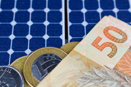 Solar panel with 50 bill of Brazilian money and coins.の写真素材