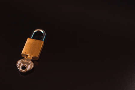 Padlock with key isolated on black background.の写真素材