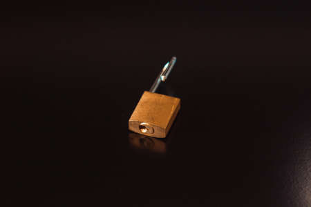 Padlock with key isolated on black background.の写真素材