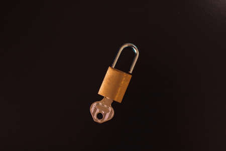 Padlock with key isolated on black background.の写真素材