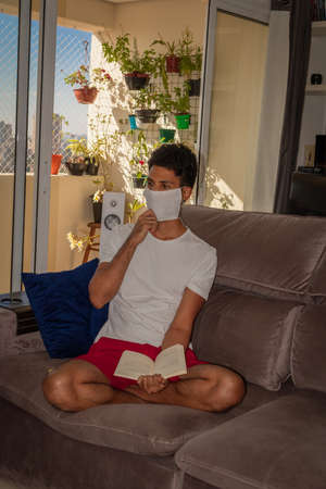 Man wearing protective mask against the coronavirus in house quarantine.の写真素材