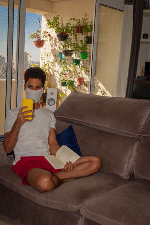 Man wearing protective mask against the coronavirus in house quarantine.の写真素材