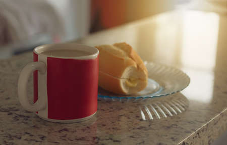 Brazilian breakfast. Cup of coffee and toasted bread with butter in the kitchen.の写真素材