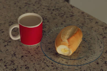 Brazilian breakfast. Cup of coffee and toasted bread with butter in the kitchen.の写真素材