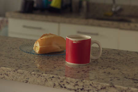 Brazilian breakfast. Cup of coffee and toasted bread with butter in the kitchen.の写真素材