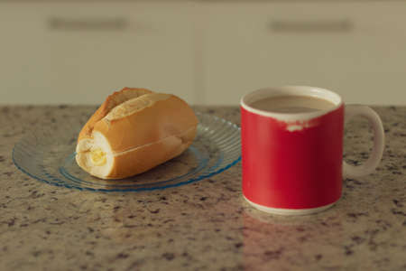 Brazilian breakfast. Cup of coffee and toasted bread with butter in the kitchen.の写真素材