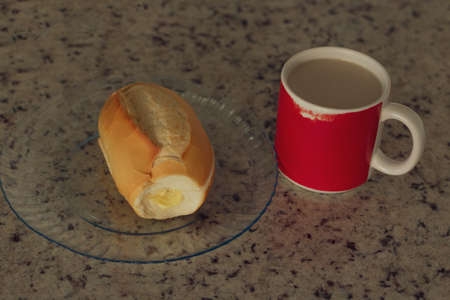 Brazilian breakfast. Cup of coffee and toasted bread with butter in the kitchen.の写真素材