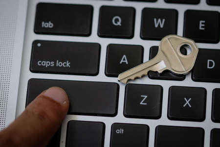 Thinger pointing to a key at keyboard. Security concept imageの写真素材