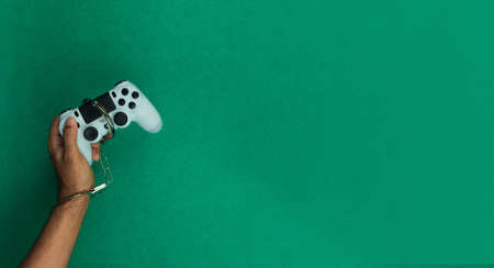 Video game joystick and handcuffs isolated. Addiction to games concept imageの写真素材