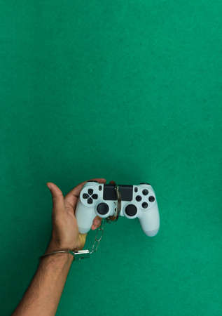 Video game joystick and handcuffs isolated. Addiction to games concept imageの写真素材