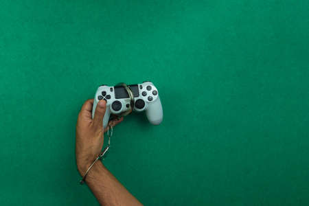Video game joystick and handcuffs isolated. Addiction to games concept imageの写真素材