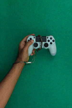 Video game joystick and handcuffs isolated. Addiction to games concept imageの写真素材