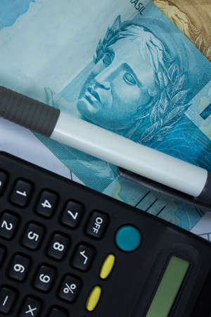 Brazilian money with calculator and numerical chart background.の写真素材