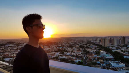 Silhouette of a man with glasses on top of a building.の写真素材