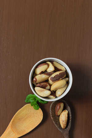 Brazilian nuts in a bowl on a wooden table.の写真素材