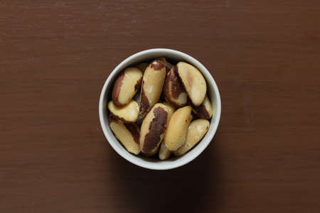 Brazilian nuts in a bowl on a wooden table.