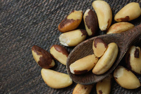 Brazilian nuts in a bowl on a wooden table.の写真素材