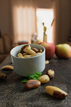 Brazilian nuts in a bowl on a wooden table.の写真素材