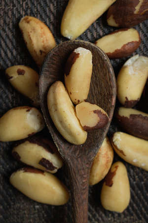 Brazilian nuts in a bowl on a wooden table.の写真素材
