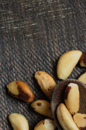 Brazilian nuts in a bowl on a wooden table.の写真素材