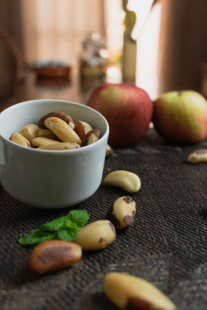 Brazilian nuts in a bowl on a wooden table.の写真素材
