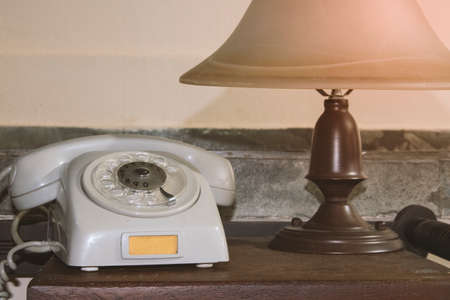 Old gray phone and retro lamp on the desk concept imageの写真素材