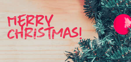 Merry Christmas text.. Merry Christmas background with xmas tree and wood table.の写真素材