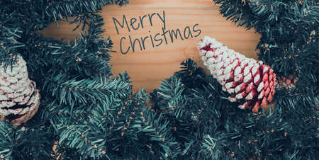 Merry Christmas text.. Merry Christmas background with xmas tree and wood table.の写真素材