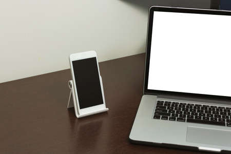 Desk Laptop blank text space screen in office on wood table. Laptop mock-up conceptual workspace...