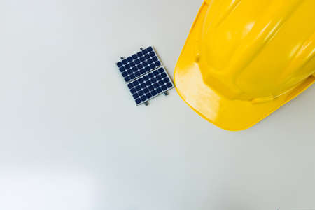 Solar Cell Energy concept image. Solar panel, safety helmet and work tools isolated on white, top...