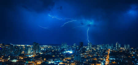 Dark sky and thunder rays in the city skylineの写真素材