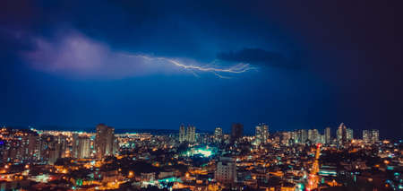Dark sky and thunder rays in the city skylineの写真素材