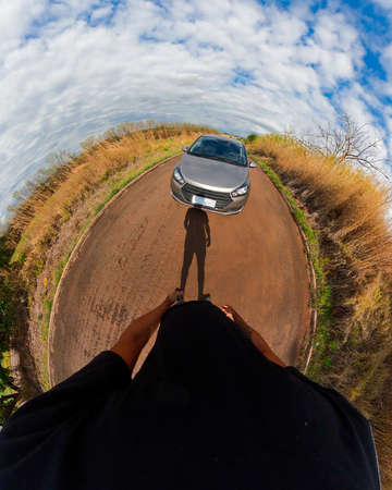Man black next to a car in countryside mini planet. 360 camera footage with black man, trees, white...