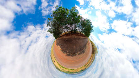 Small planet with trees, white clouds and soft blue sky. Green 360 Tiny planet of green grass...