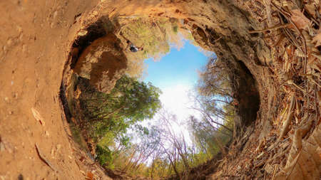Young man with backpack exploring nature in front of a waterfall. Green life concept imageの写真素材
