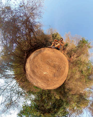 Young man with backpack exploring nature in front of a waterfall. Green life concept imageの写真素材