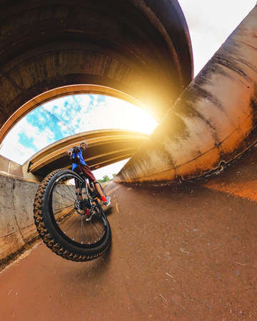 Cheerful black man with bicycle going for a ride in downtown, looking at camera in the setting sun....