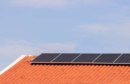 Solar photovoltaic panels on a roof at sunset. Clean energy modern house or company concept image.