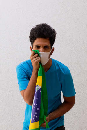 Black Man With Pandemic Mask Holding a Brazil Flag Isolated On White