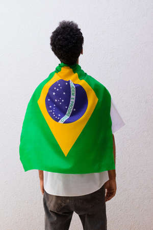 Back of a man with Brazilian flag hero cape isolated on white.の写真素材
