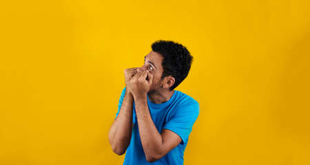 Scared man isolated on yellow background. Handsome Black Man with blue shirt on yellow.の写真素材
