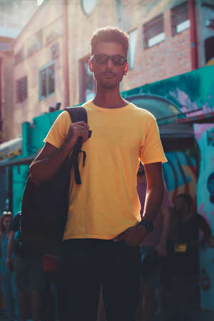 Handsome Black Man in Yellow Shirt and Glasses on Street Background Defocused People.の写真素材