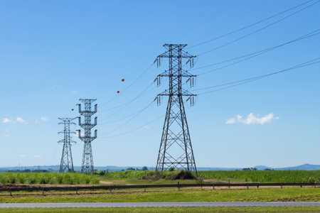 A power transmission high voltage tower in countryside isolated on sunset with some nice warm clouds in the sky. Summer urban photography.の写真素材