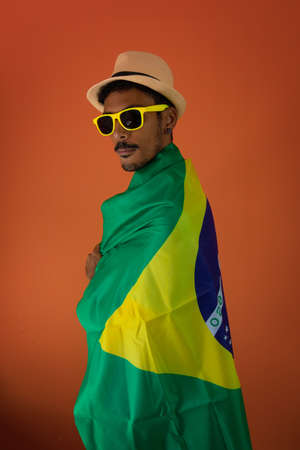 Black man in costume for carnival with brazil flag isolated on orange background.の写真素材
